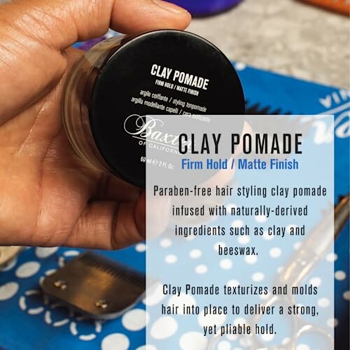 Hand holding a jar of clay pomade with product description text.