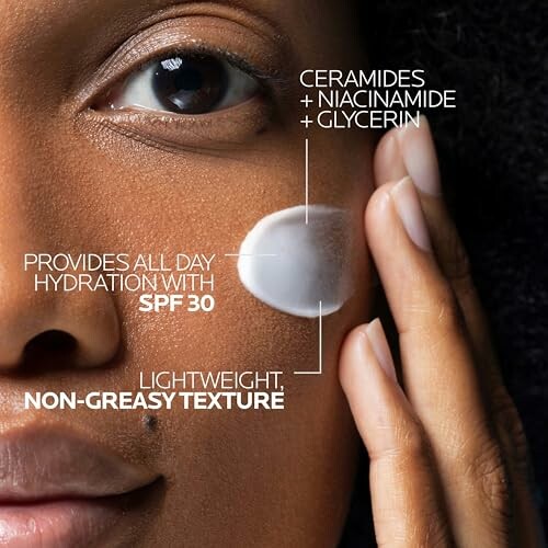 Close-up of person applying skincare cream with SPF 30 on face.