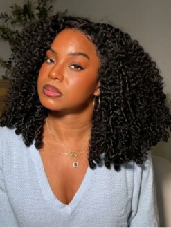Woman with curly hair wearing a blue sweater.